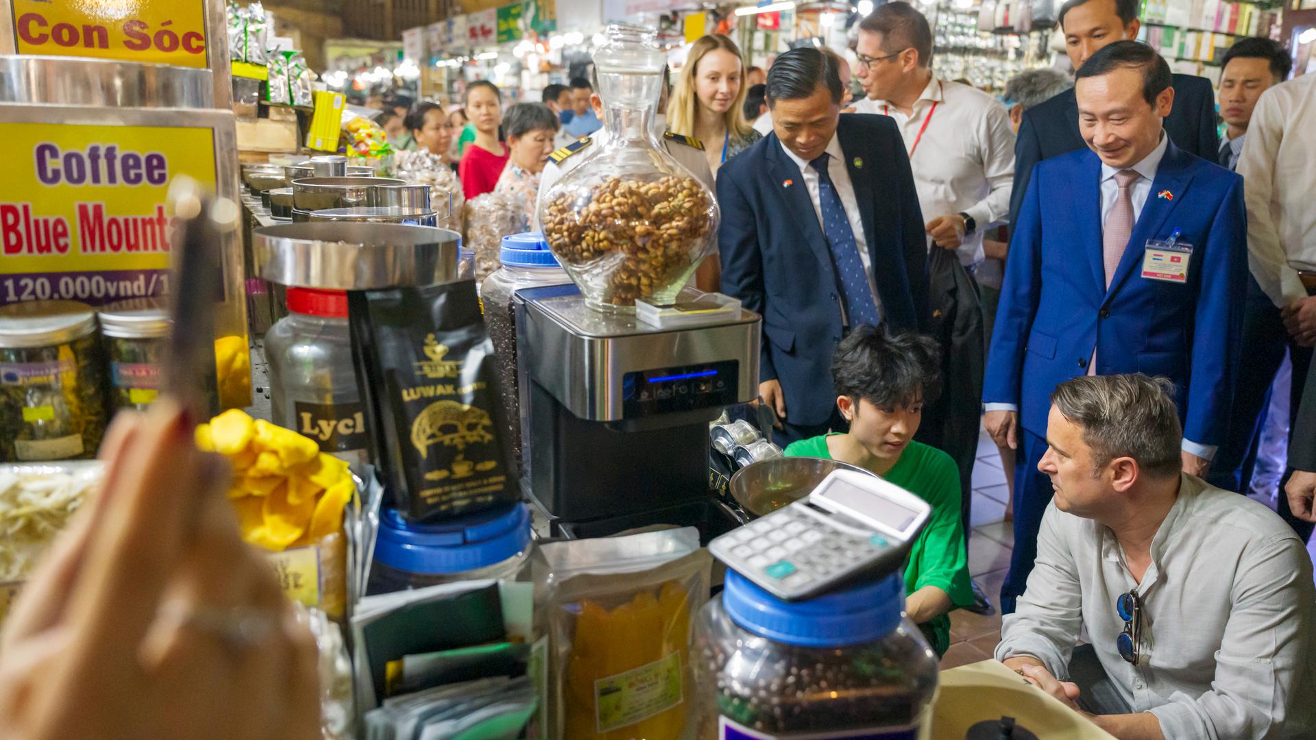 Xavier Bettel fala com um vendedor no mercado de Bên Thành em Hô Chi Min, antiga cidade de Saigão.