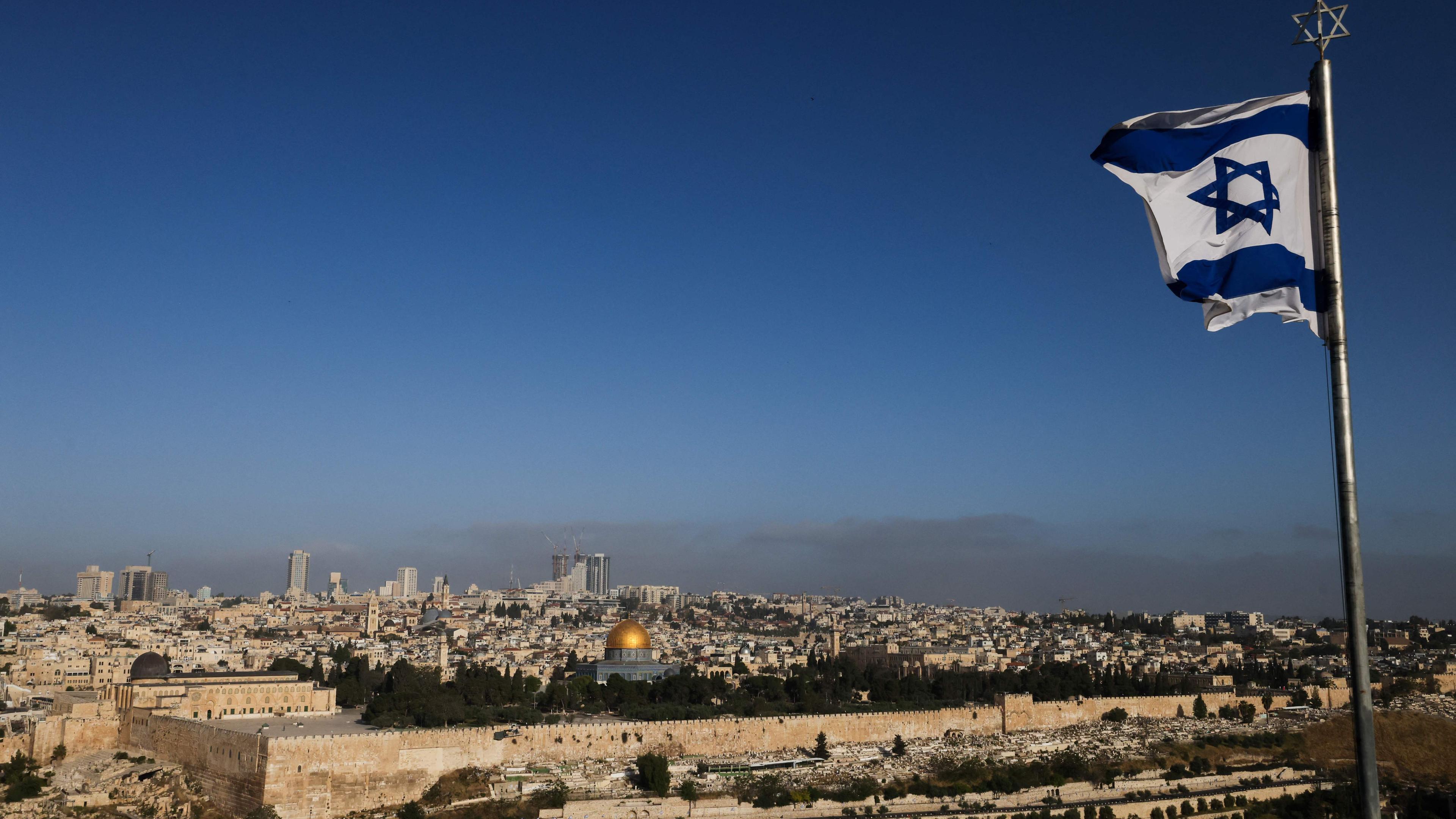 TOPSHOT - An Israeli flag flies on the Mount of Olives overlooking the Al Aqsa mosque compound and the city skyline in Jerusalem on April 19, 2024. US media quoted officials saying Israel had carried out retaliatory strikes on its arch-rival Iran, while Iran's state media reported explosions in the central province of Isfahan on April 19. (Photo by Ahmad GHARABLI / AFP)