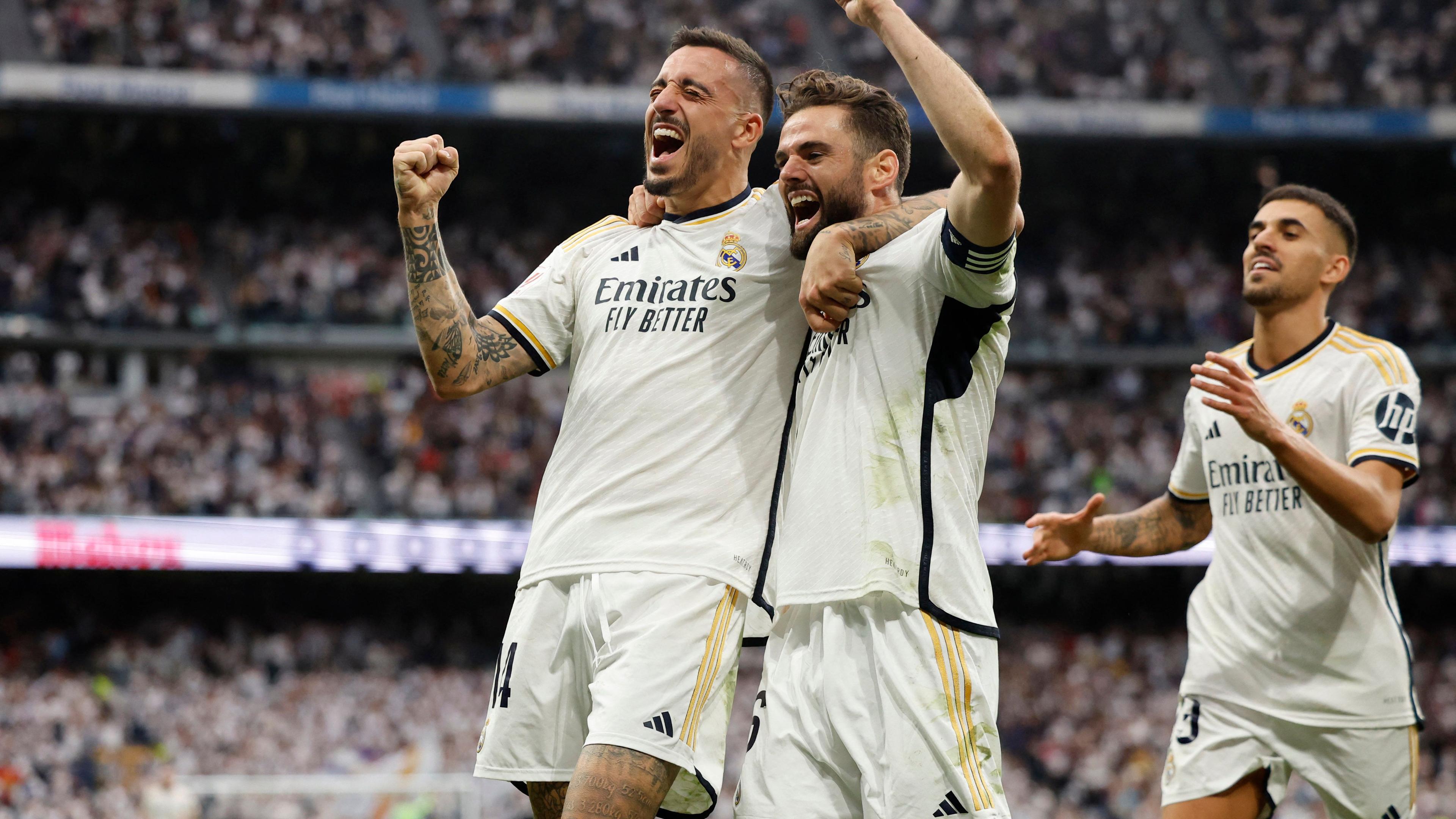 TOPSHOT - Real Madrid's Spanish forward #14 Joselu (L) celebrates scoring his team's third goal, with Real Madrid's Spanish defender #06 Nacho Fernandez, during the Spanish league football match between Real Madrid CF and Cadiz CF at the Santiago Bernabeu stadium in Madrid on May 4, 2024. (Photo by OSCAR DEL POZO / AFP)