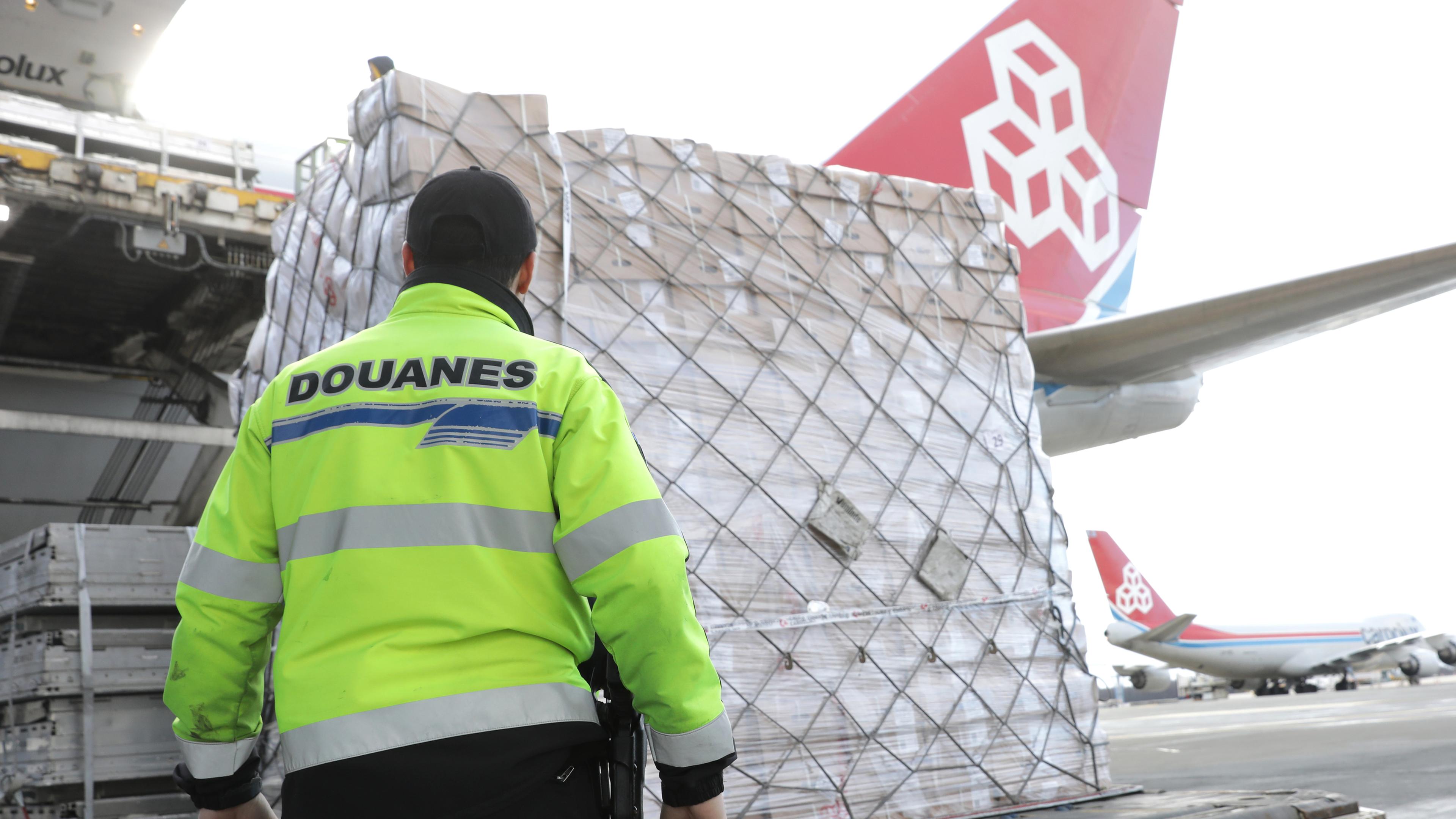 A Luxembourg customs inspector watches as a Cargolux jet is loaded at the country’s airport