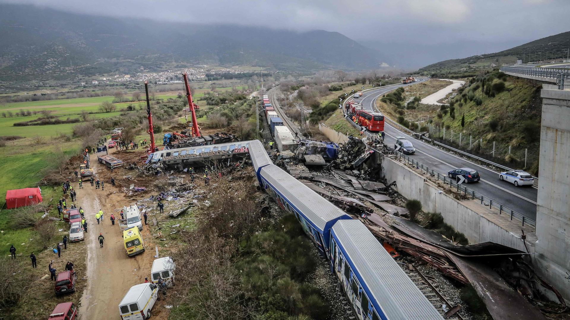 Police and emergency crews search the debris of a crushed wagon after a train accident in the Tempi Valley near Larissa, Greece, March 1, 2023. - At least 32 people were killed and another 85 injured after a collision between two trains caused a derailment near the Greek city of Larissa late at night on February 28, 2023, authorities said. A fire services spokesman confirmed that three carriages skipped the tracks just before midnight after the trains -- one for freight and the other carrying 350 passengers �- collided about halfway along the route between Athens and Thessaloniki. (Photo by Zekas LEONIDAS / Eurokinissi / AFP)