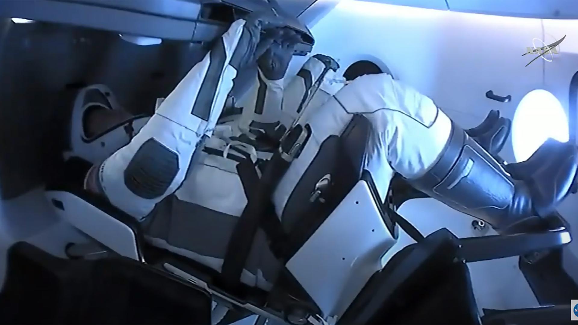 Os dois astronautas dentro da cápsula aquando do início da viagem entre a ISS e a Terra.