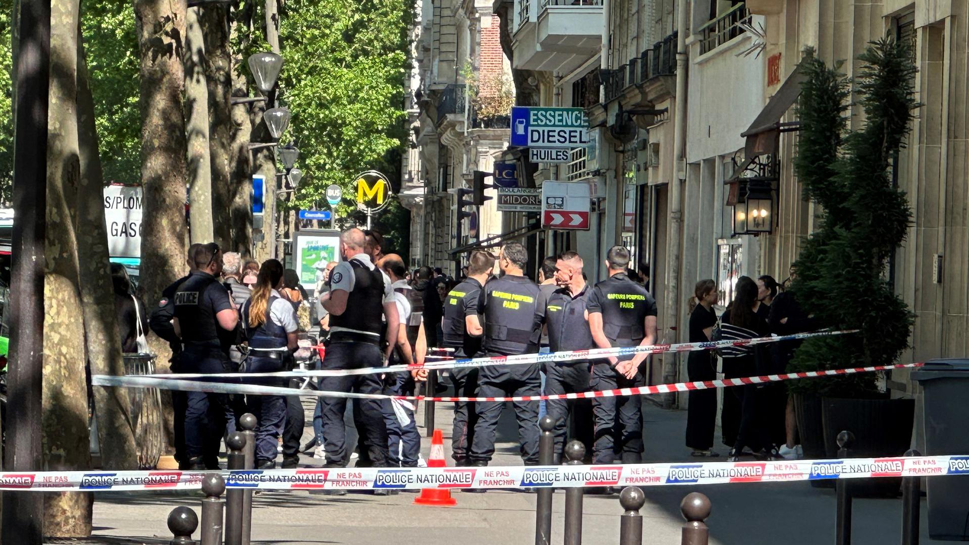 Police and firefighting personnel gather at the scene of a shooting in Paris on May 24, 2023, after gunmen on two scooters reportedly opened fire and killed one person on Boulevard de Courcelles in the centre of the French capital. (Photo by Philippe DUPEYRAT / AFP)