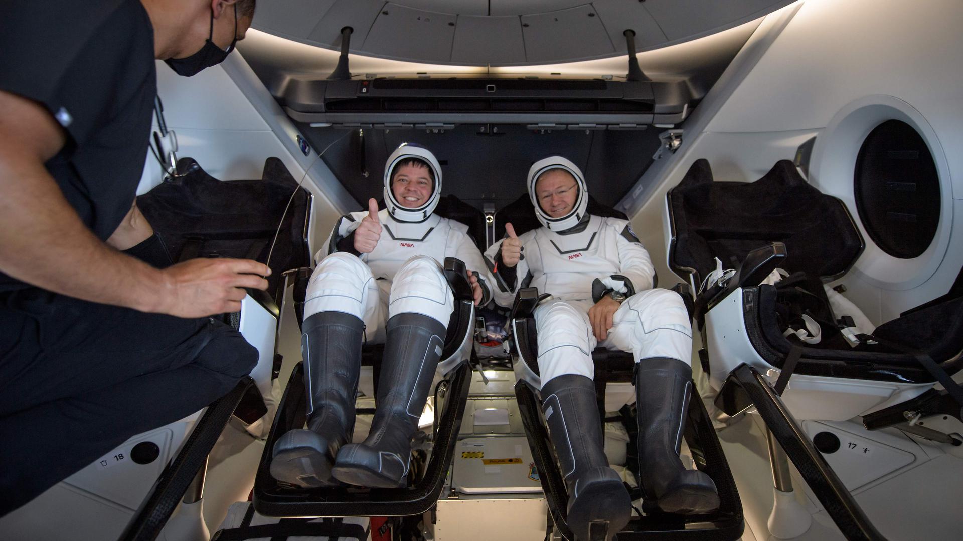 Robert Behnken e Douglas Hurley ainda dentro da cápsula Dragon da SpaceX minutos após a aterragem na água.