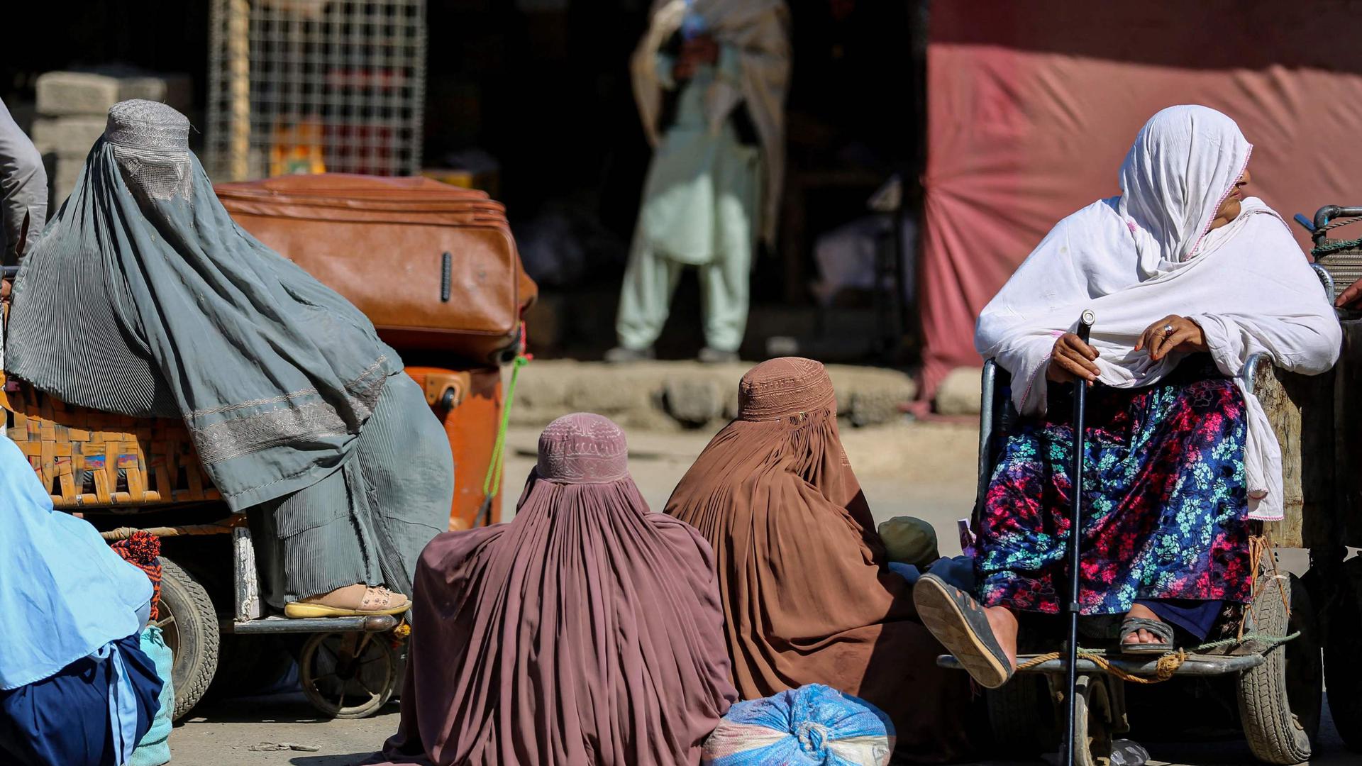 Mulheres afegãs esperam para atravessar a fronteira com o Paquistão, perto de Torkham. 