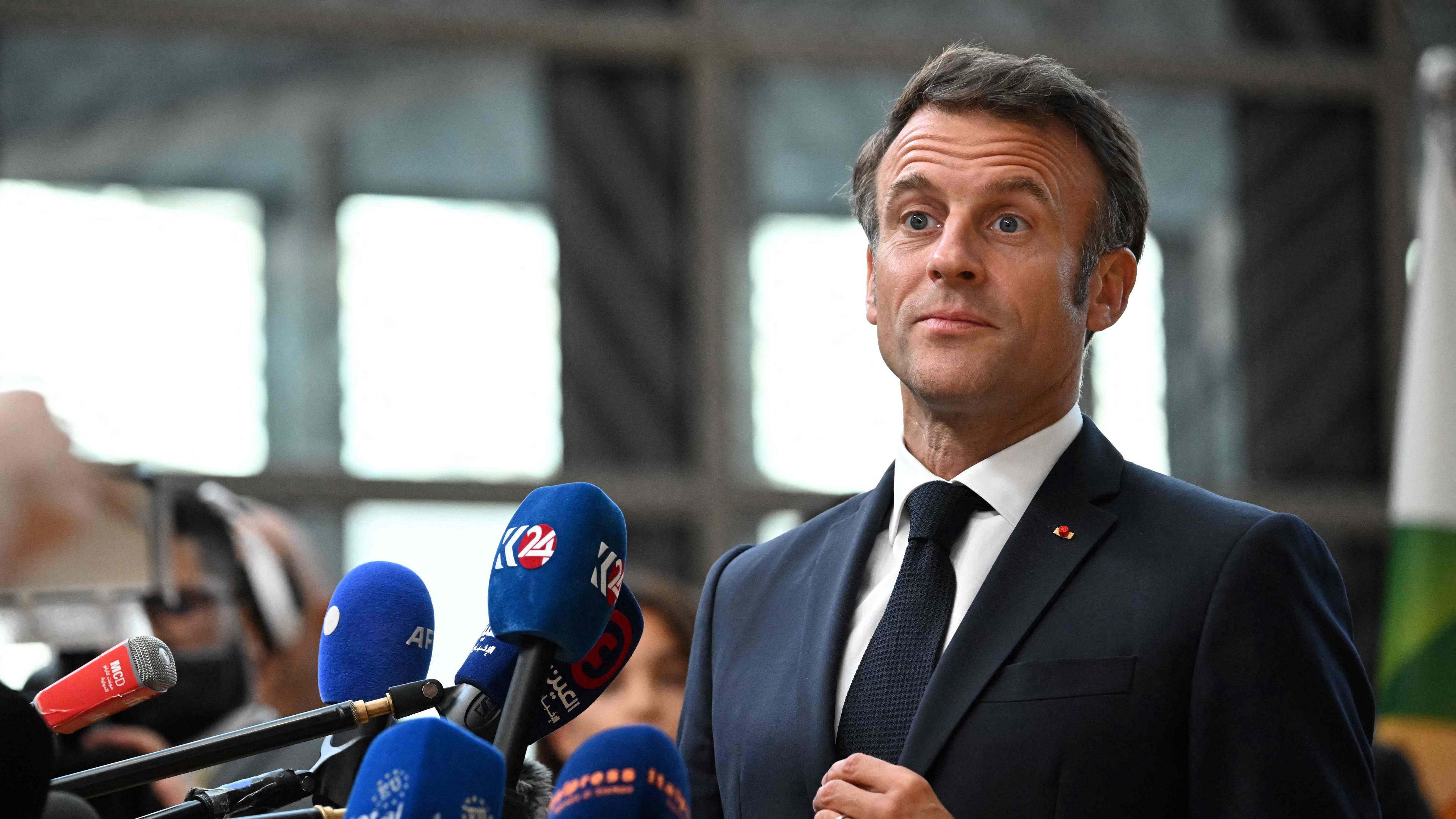 France's President Emmanuel Macron talks to the press as he leaves after attending the plenary session of a summit of the European Union and the Community of Latin American and Caribbean States (EU-CELAC) at the European Council Building in Brussels on July 18, 2023. (Photo by Emmanuel DUNAND / AFP)