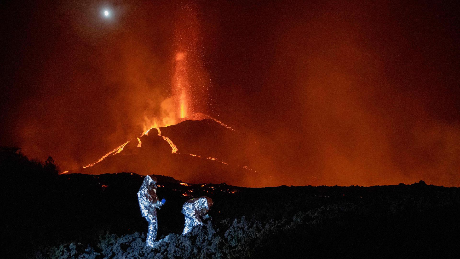 Membros do grupo de intervenção de emergências tecnológicas e ambientais monitorizam a evolução da nova lava que tem 'jorrado' do vulcão Cumbre Vieja.