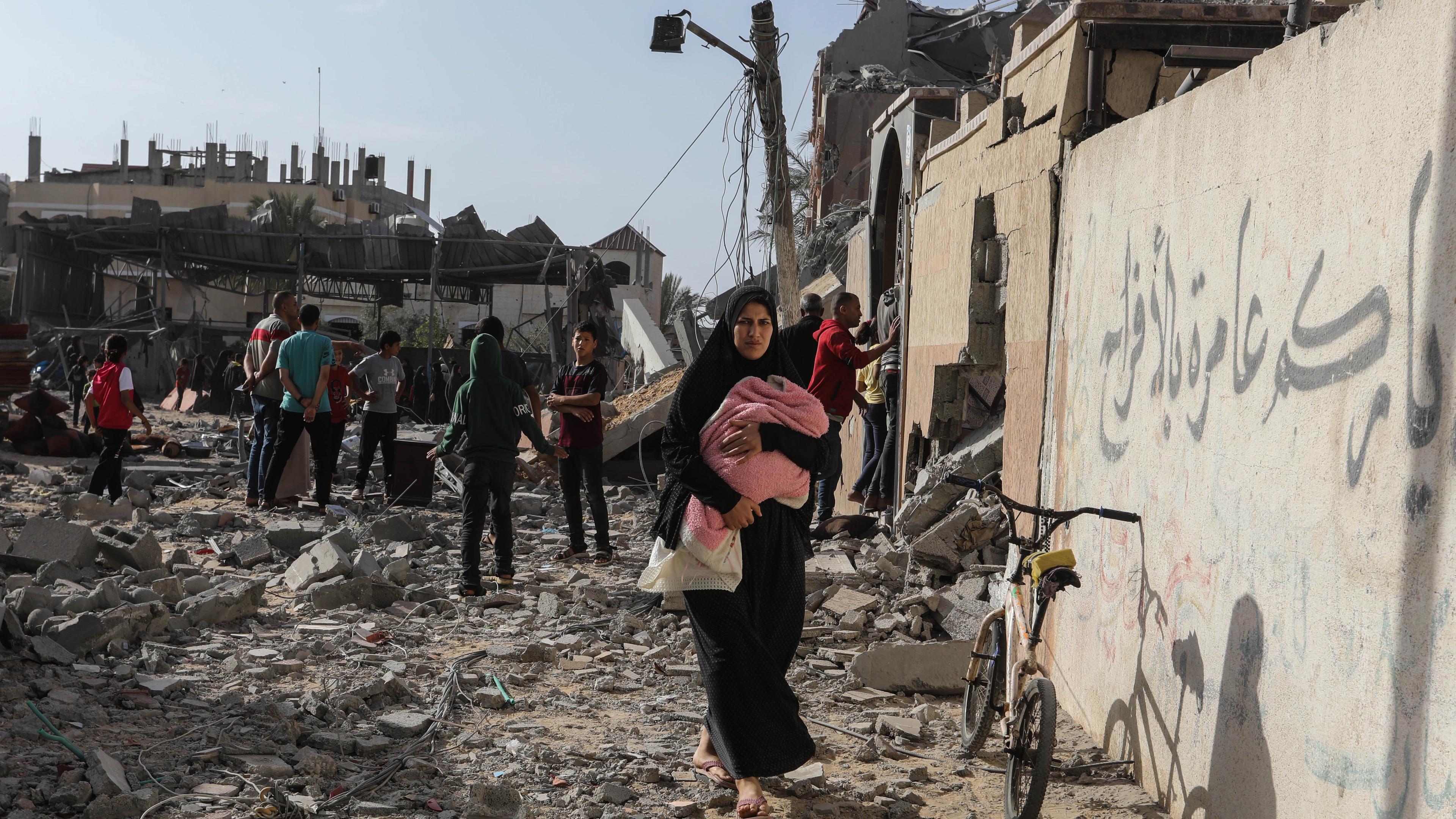 ARCHIV - 05.05.2024, Palästinensische Gebiete, Rafah: Palästinenser inspizieren beschädigte Häuser, nachdem israelische Kampfflugzeuge ein Haus bombardiert hatten. Vor einem erwarteten Militäreinsatz hat Israels Armee am Montag (06.05.2024) mit der Evakuierung der Stadt Rafah im südlichen Gazastreifen begonnen. Das Militär rief die Einwohner des östlichen Teils der Stadt an der Grenze zu Ägypten dazu auf, sich in das einige Kilometer nördlich gelegene Al-Mawasi-Lager am Mittelmeer zu begeben. Foto: Abed Rahim Khatib/dpa +++ dpa-Bildfunk +++
