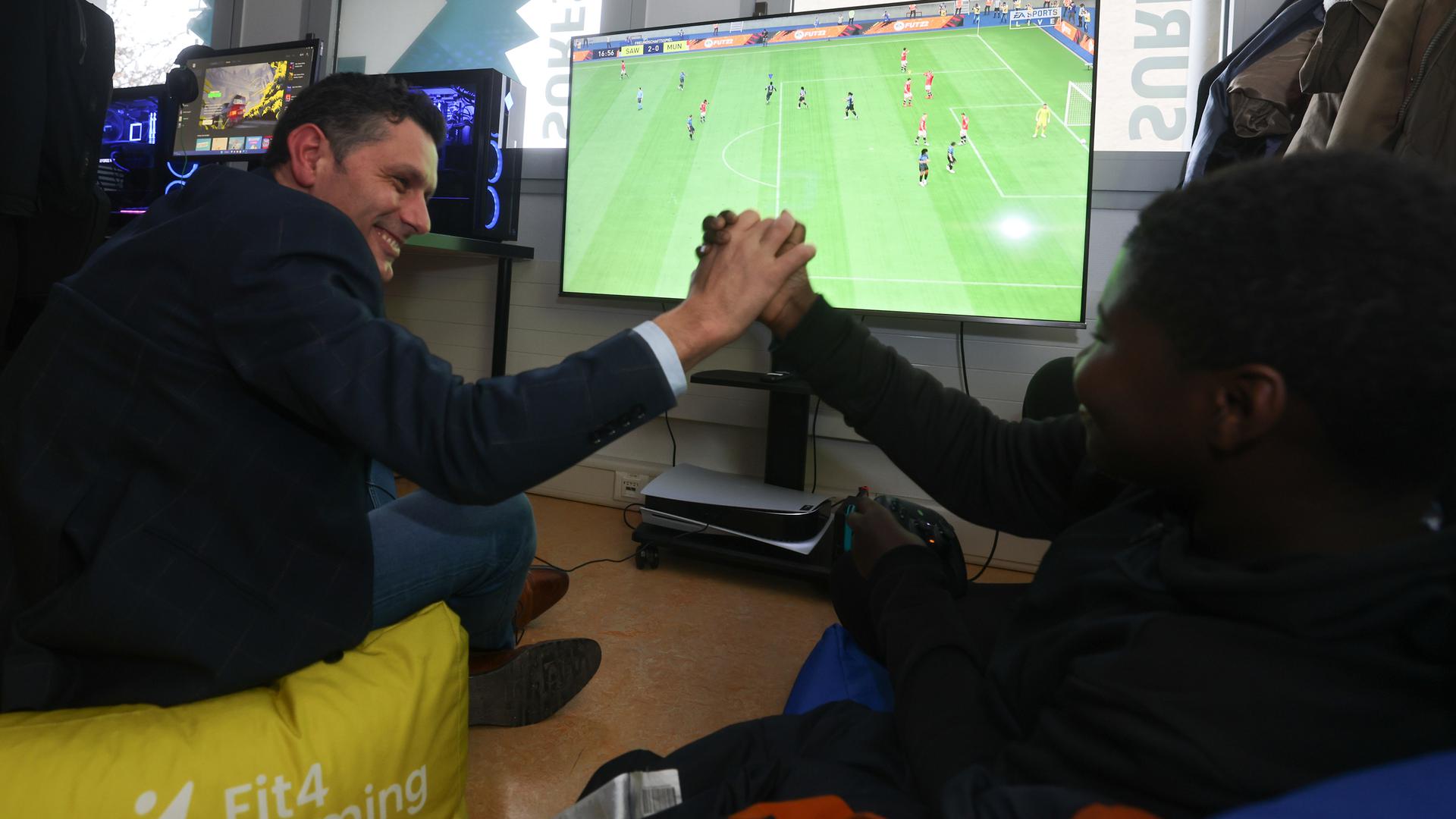 Paulo Aguiar, 45 anos, joga FIFA com Januário, 11 anos no espaço Fit4Gaming.