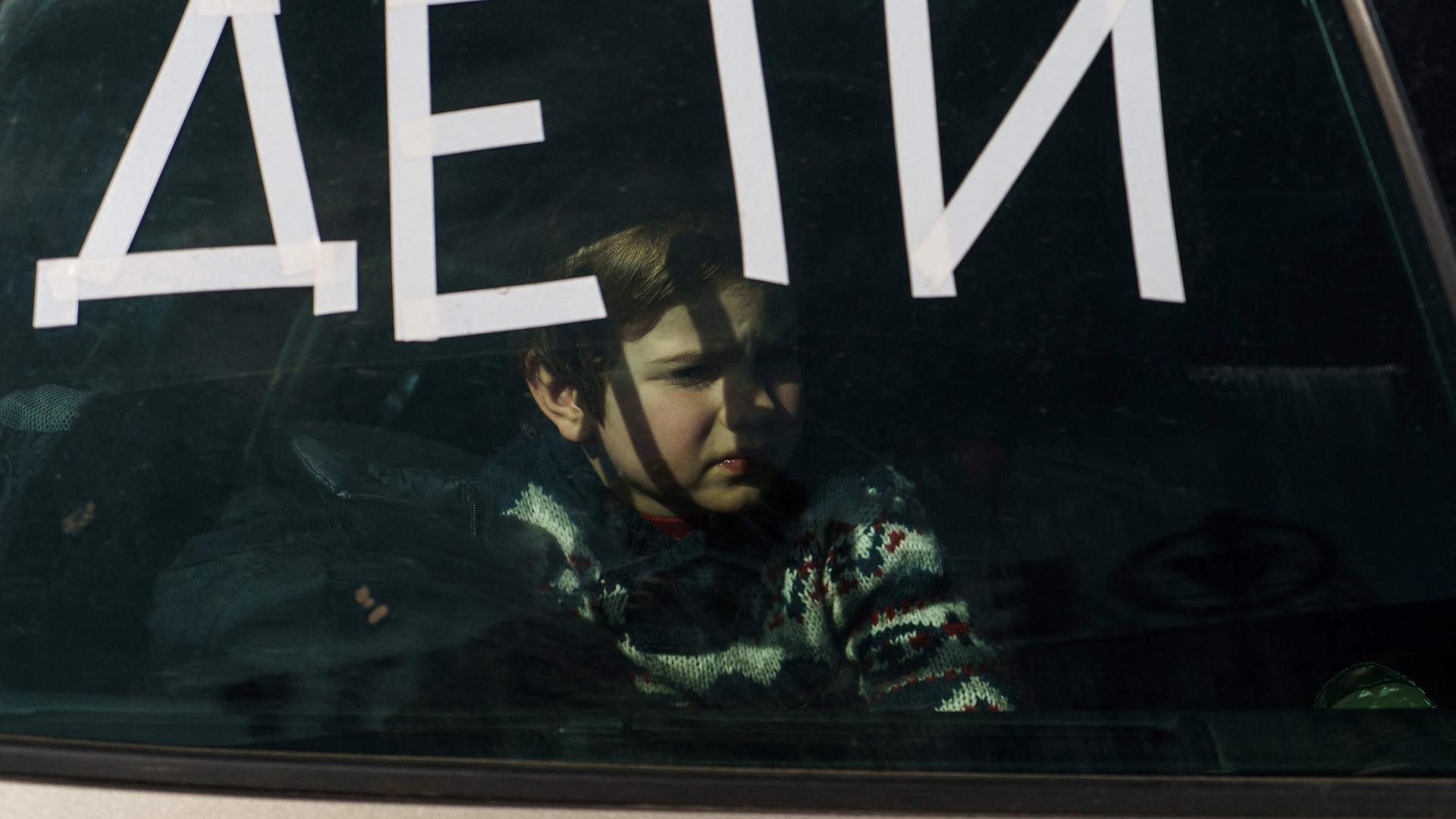 Uma criança dentro de um carro com a palavra "criança" em ucraniano, à chegada a um ponto de evacuação em Zaporizhzhya, a 29 de março de 2022.