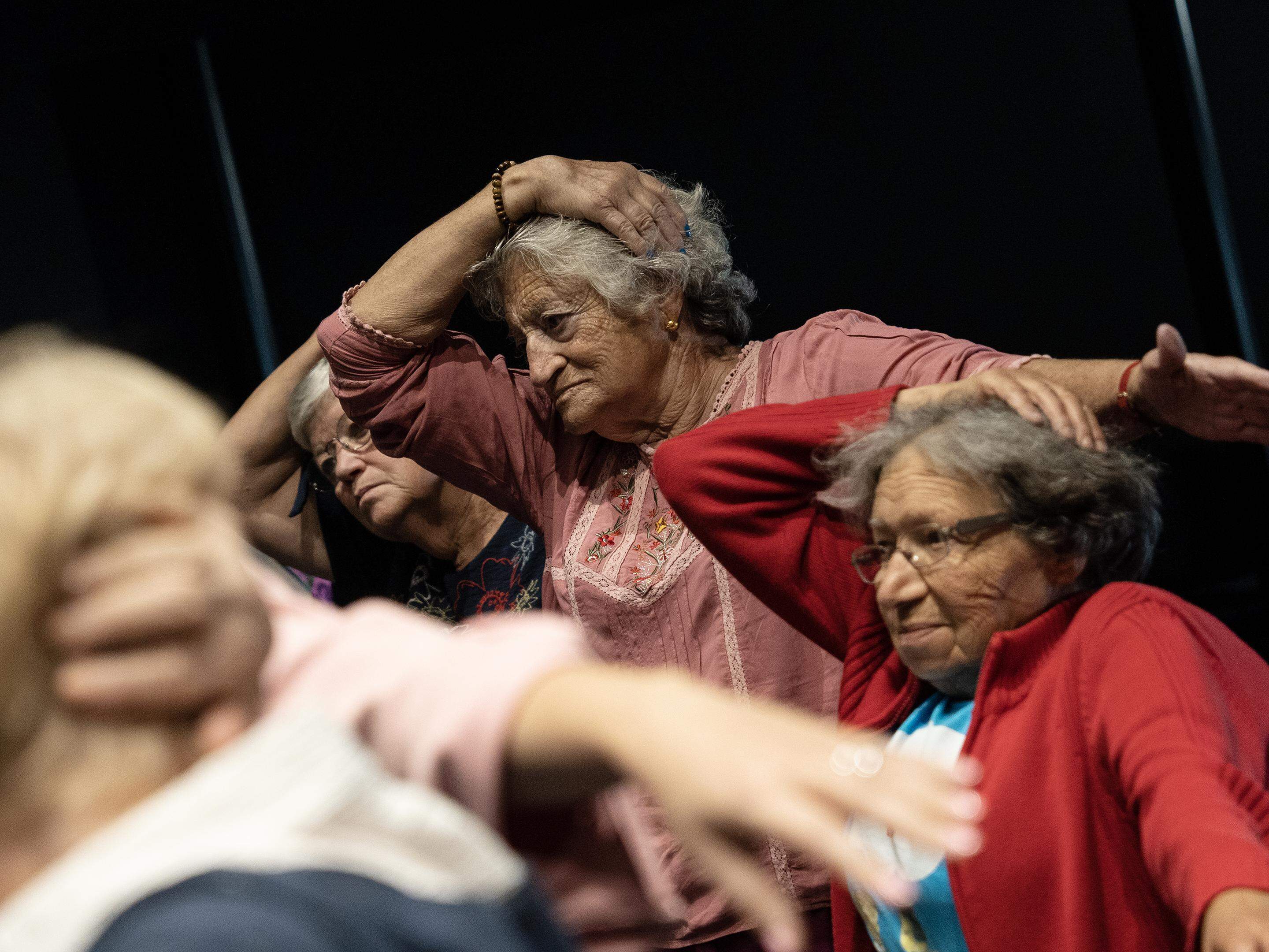 Um grupo de pessoas sentadas em volta de um presente de natal