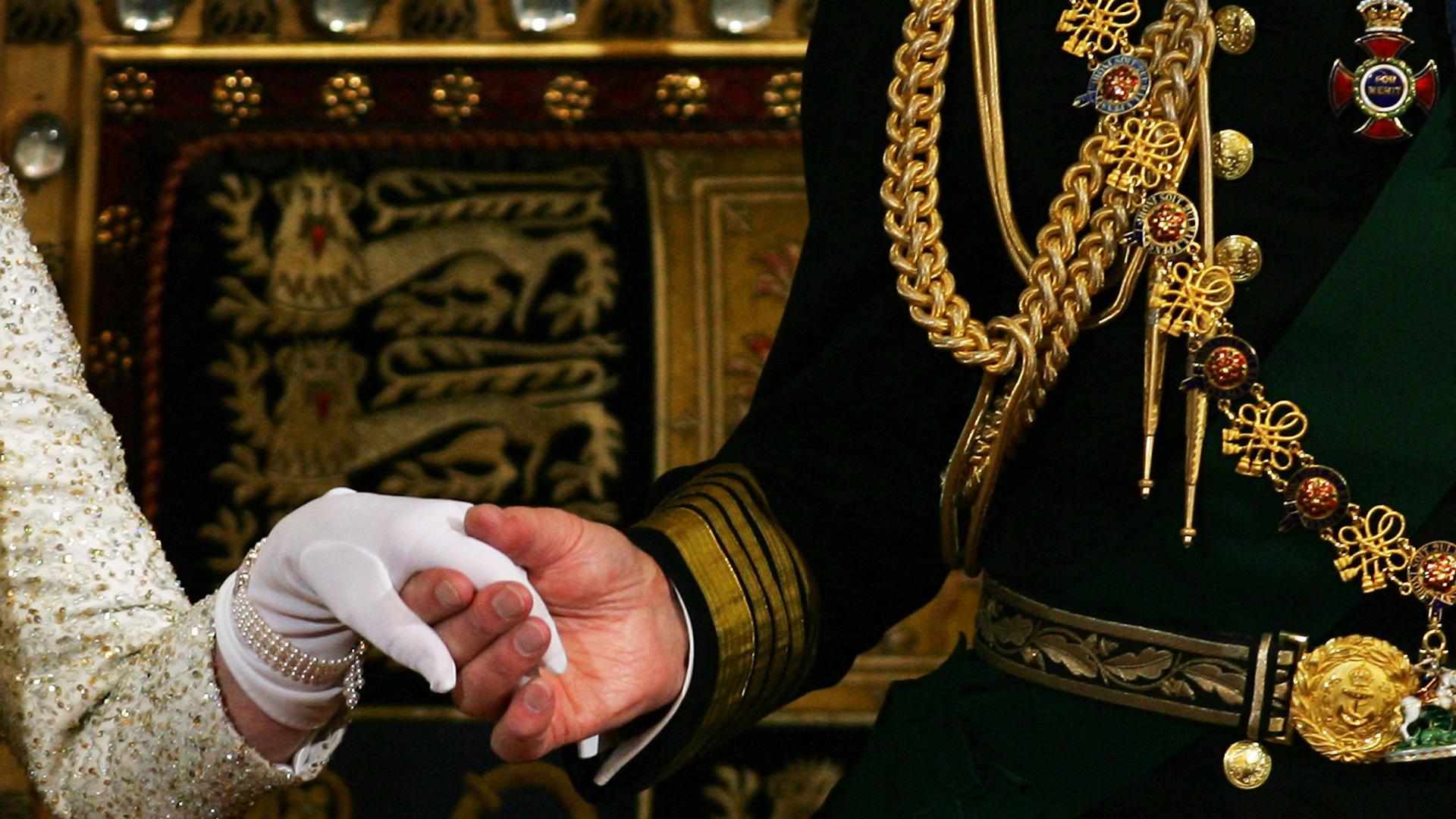 (FILES) In this file photo taken on November 15, 2006 Britain's Prince Philip, Duke of Edinburgh (R) holds the Britain's Queen Elizabeth II's (L) hand as she steps down after reading her speech during the State Opening of Parliament in London. - Queen Elizabeth II's 99-year-old husband Prince Philip, who was recently hospitalised and underwent a successful heart procedure, died on April 9, 2021, Buckingham Palace announced. (Photo by Adrian DENNIS / POOL / AFP)