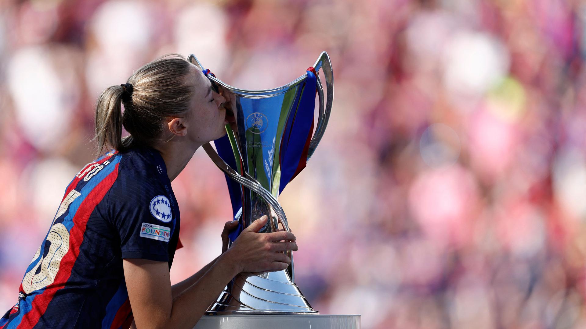 TOPSHOT - Barcelona's Swedish forward Fridolina Rolfo kisses the trophy on the podium after her team's victory in the UEFA Women's Champions League final football match between FC Barcelona and Wolfsburg in Philips Stadium, in Eindhoven, on June 3, 2023. (Photo by KENZO TRIBOUILLARD / AFP)