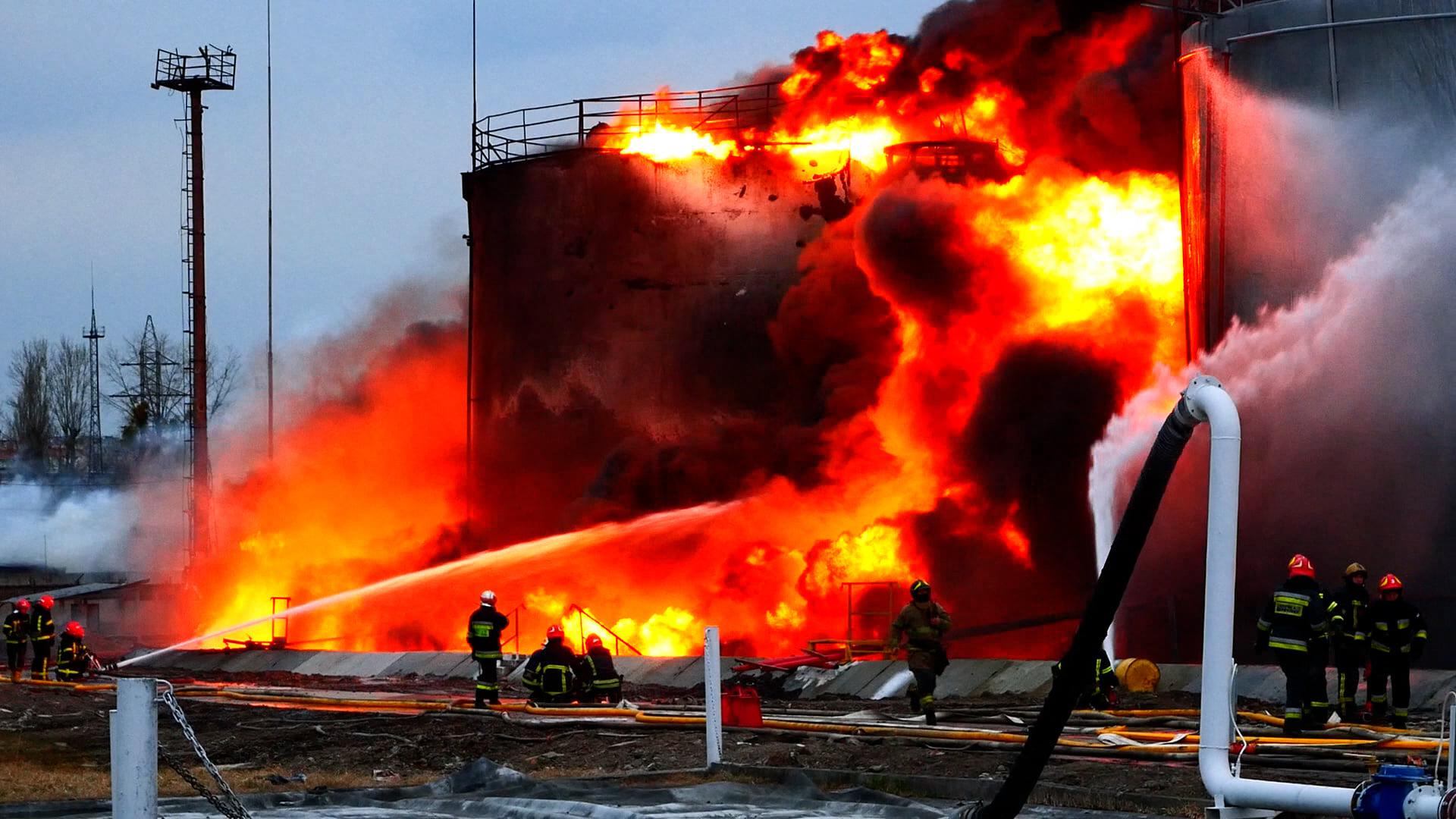 Bombeiros tentam apagar um incêndio após a queda de mísseis russos numa instalação de armazenamento de combustível na cidade ucraniana ocidental de Lviv