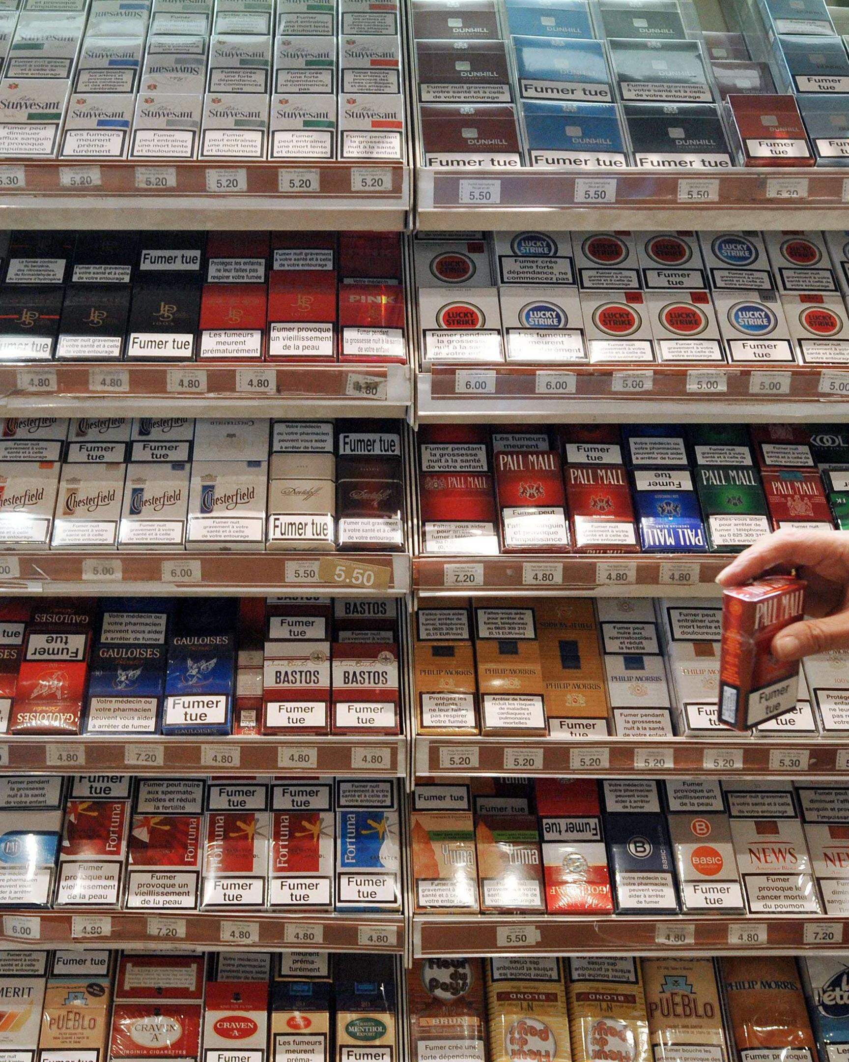 (FILES) -- A file photo taken on Octobre 14, 2009 in Bordeaux shows a tobacconist holding a pack of cigarettes. Belgium tobacco sales have soared to record heights this year as cheap cigarettes and tobacco lure discount-seeking smokers from Britain and France, the daily Le Soir said on November 12, 2011. As health experts complained that Belgium's cheap tobacco goods fanned cancer, Le Soir, citing exclusive data from the country's finance ministry, said cigarette sales leapt 19 percent in the first nine months of the year though the national tobacco federation said domestic sales were sliding.   AFP PHOTO / PIERRE ANDRIEU