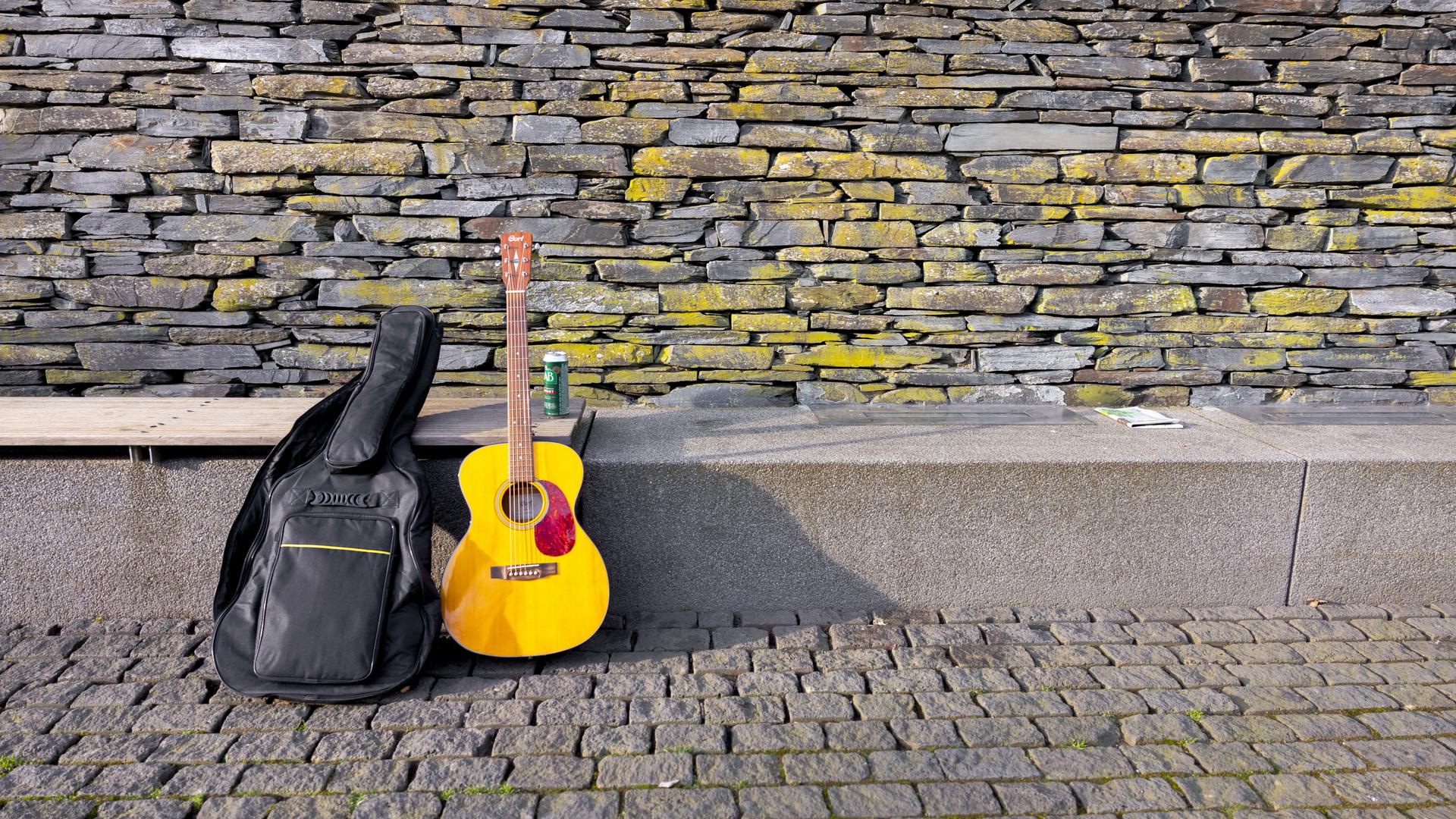 Com a sua guitarra, o sem-abrigo pode ganhar algum dinheiro. 