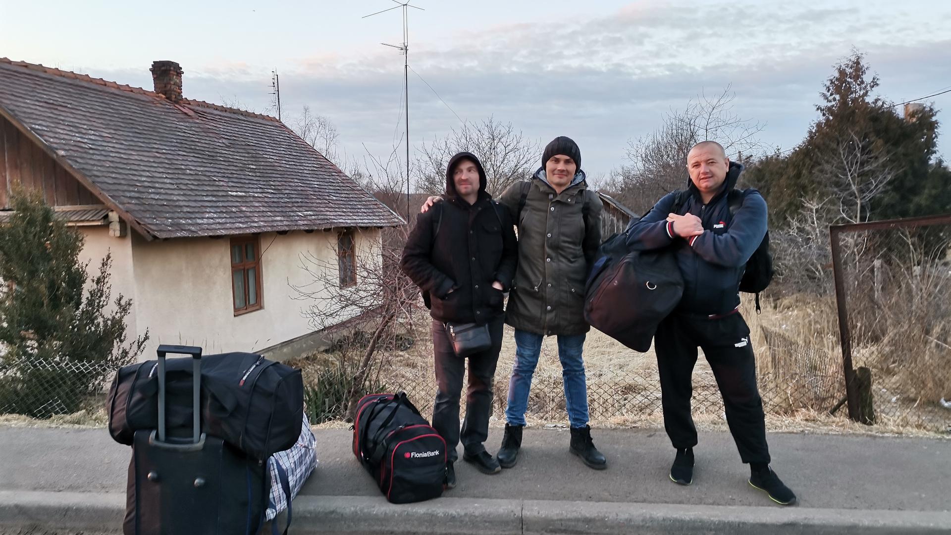 A guerra apanhou o camionista Sasha, à direita, fora do país. Agora ele regressa a casa, perto de Mariupol, para saber se a sua mulher e filhos estão bem.