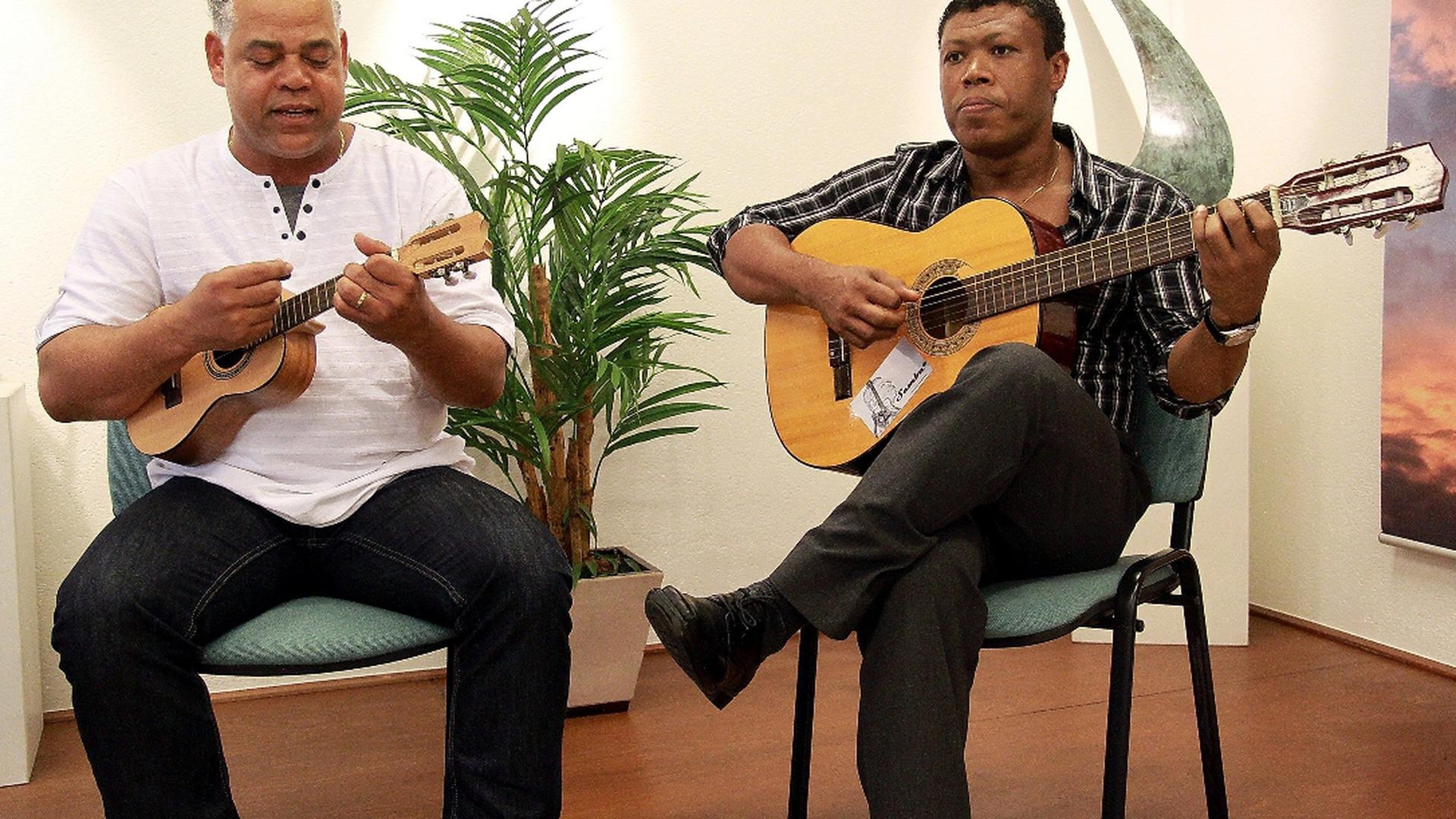 Os músicos cabo-verdianos Samba e D’Joy que, no cavaquinho e no violão (guitarra em Portugal), acompanharam João da Luz, ilustrando os tipo de música do arquipélago
