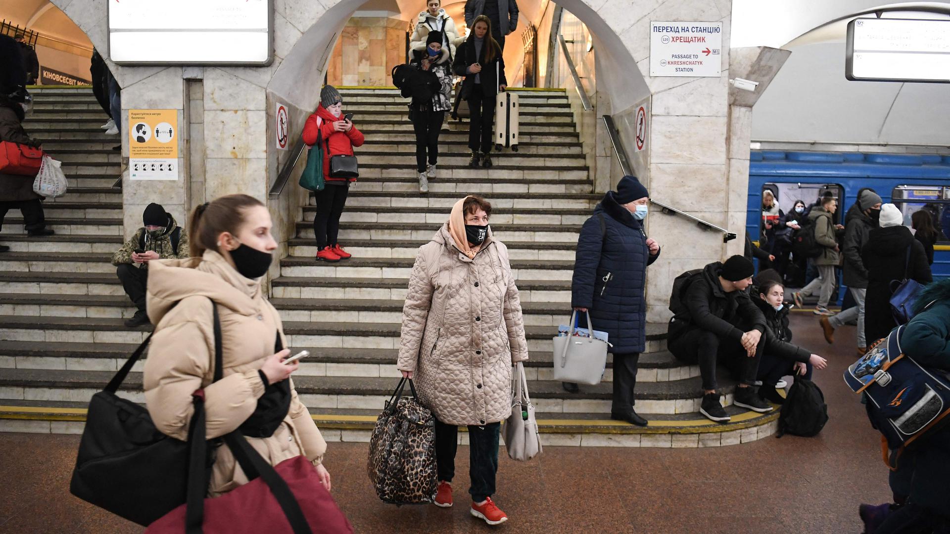 Pessoas com sacos e malas numa estação de metro na capital ucraniana esta quinta-feira de manhã.