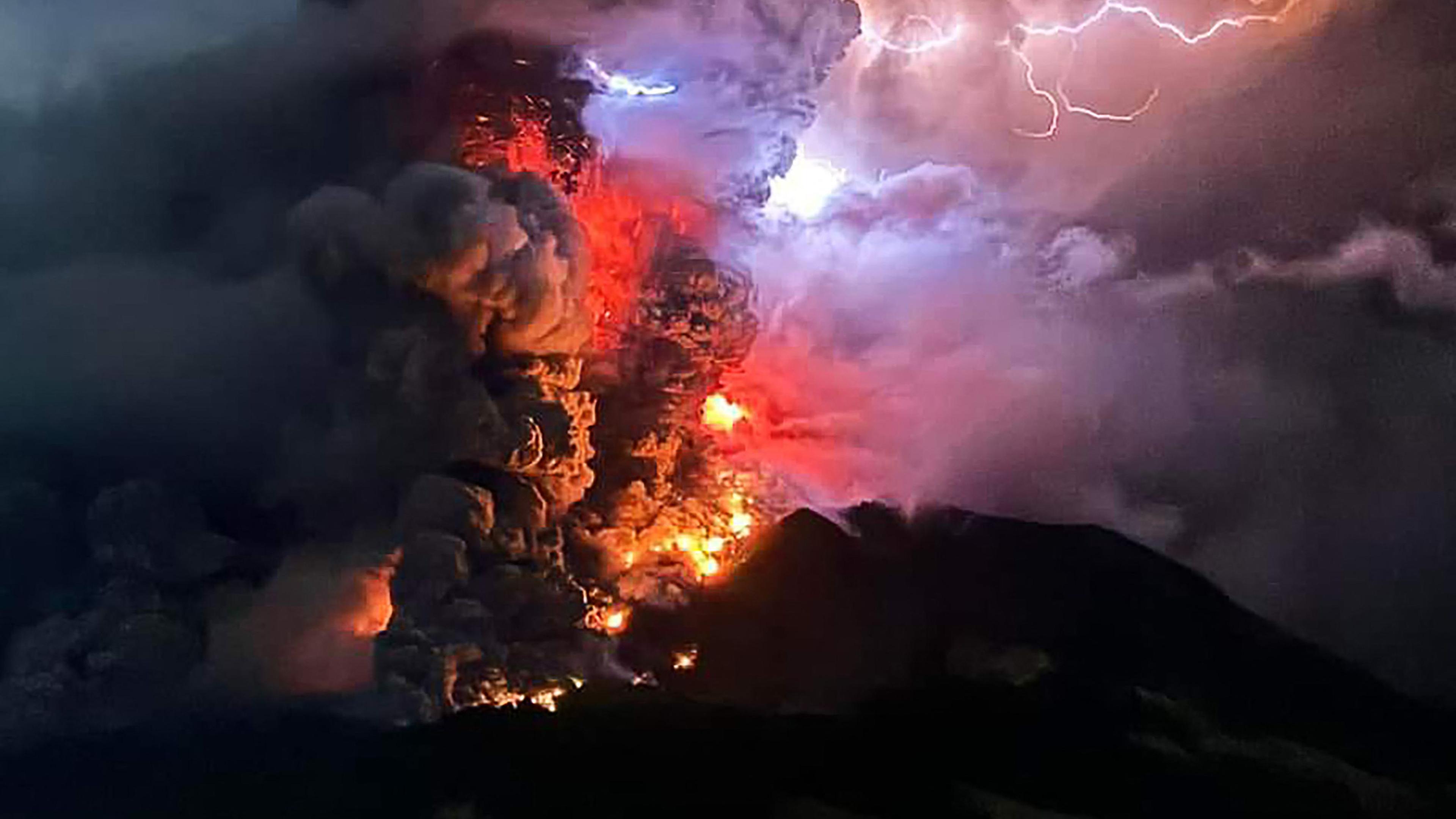 TOPSHOT - This handout photograph taken and released by the Center for Volcanology and Geological Hazard Mitigation on April 17, 2024, shows Mount Ruang spewing hot lava and smoke as seen from Sitaro, North Sulawesi. A volcano erupted several times in Indonesia's outermost region overnight on April 17, forcing hundreds of people to be evacuated after it spewed lava and a column of smoke more than a mile into the sky. (Photo by Handout / Center for Volcanology and Geological Hazard Mitigation / AFP) / RESTRICTED TO EDITORIAL USE - MANDATORY CREDIT AFP PHOTO / CENTER FOR VOLCANOLOGY AND GEOLOGICAL HAZARD MITIGATION/ PVMBK - NO MARKETING - NO ADVERTISING CAMPAIGNS- DISTRIBUTED AS A SERVICE TO CLIENTS