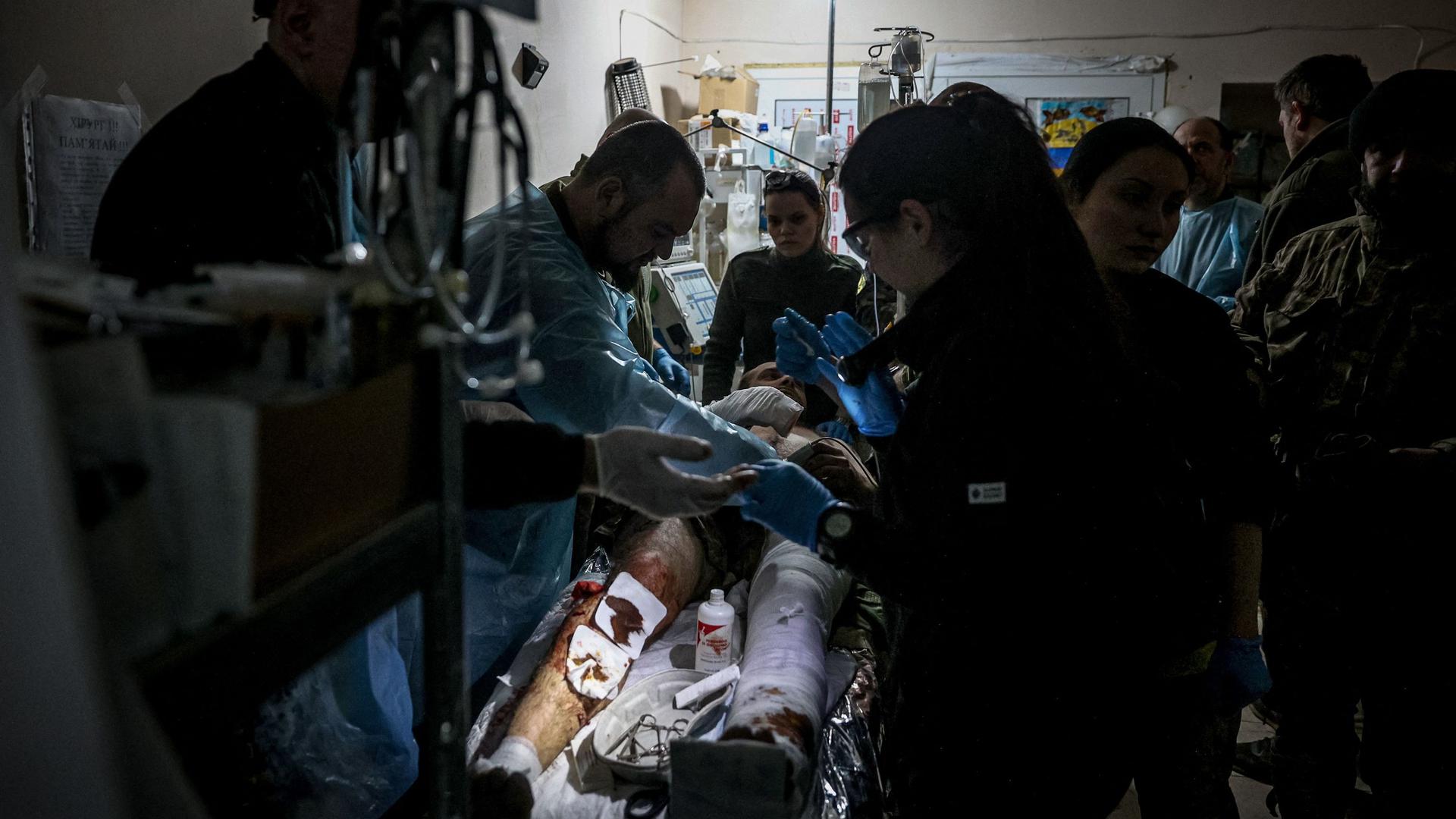 TOPSHOT - A wounded Ukrainian soldier receives treatment at a stabilising mobile hospital in the vicinity of Bakhmut, Donetsk region, on December 3, 2022, amid the Russian invasion of Ukraine. (Photo by ANATOLII STEPANOV / AFP)
